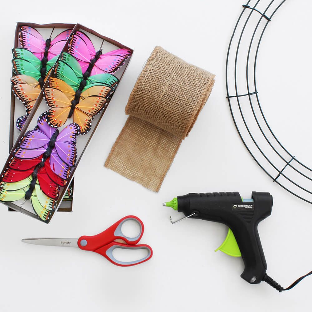 flat lay of paper mart butterflies, burlap ribbon, and hot glue