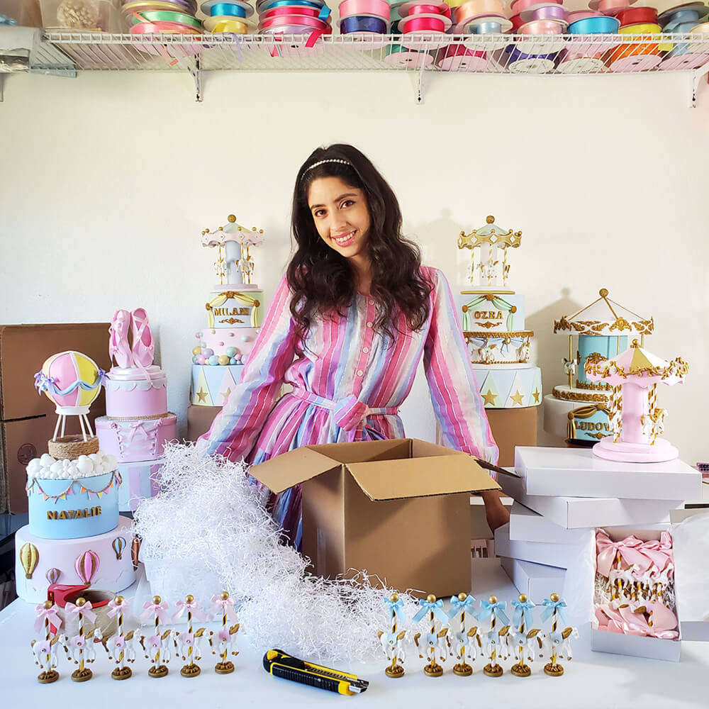 Owner and founder of Smashing Cake Toppers, Analy Garcia with Paper Mart boxes, cushioning, and Paper Mart ribbons